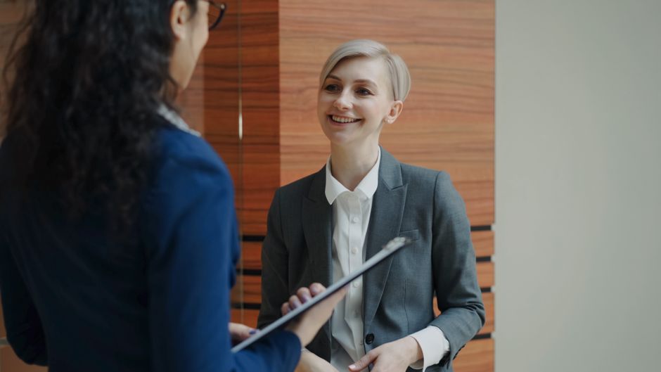 Two professionals having a conversation during a business meeting indoors